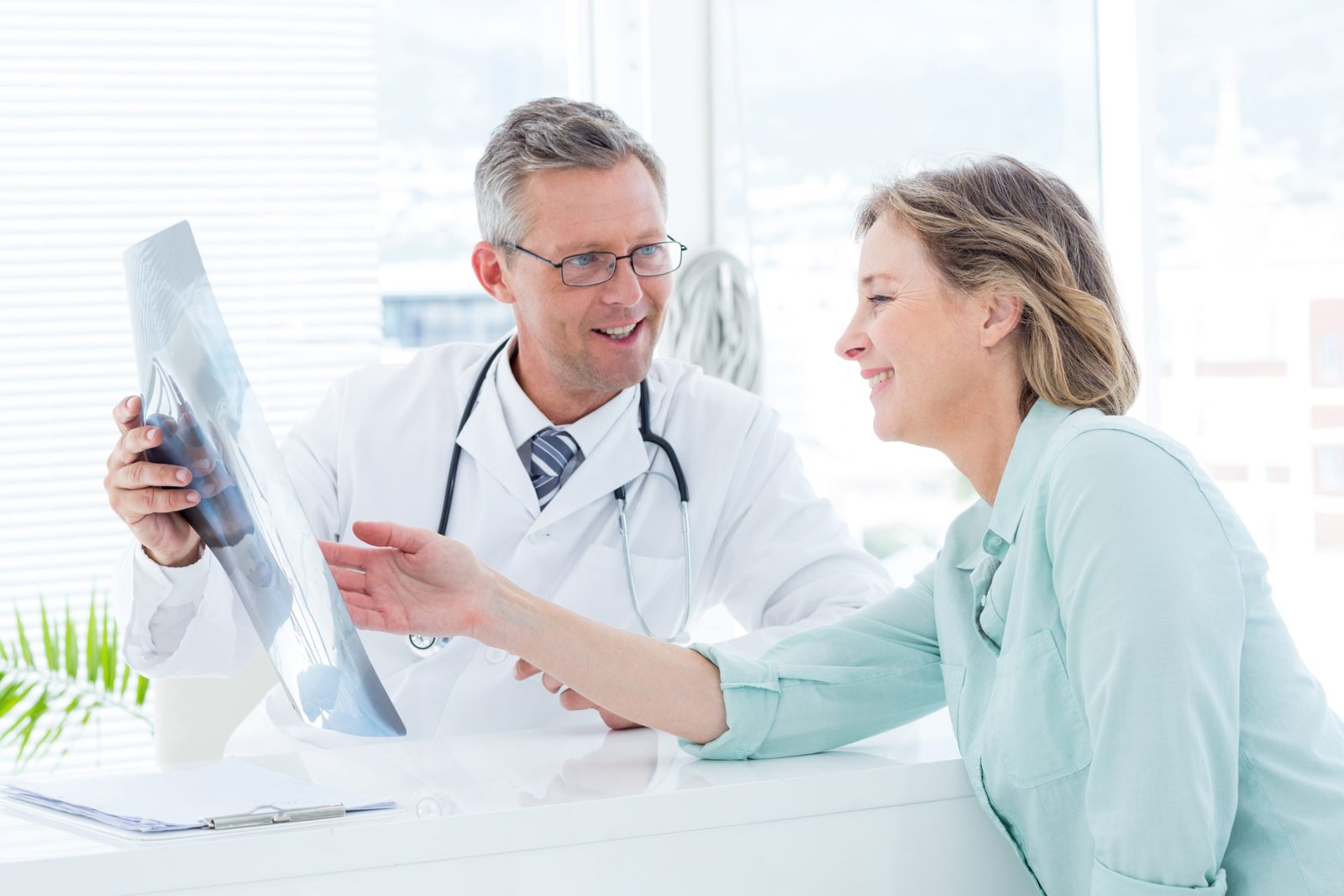 Doctor having conversation with his patient and holding xray